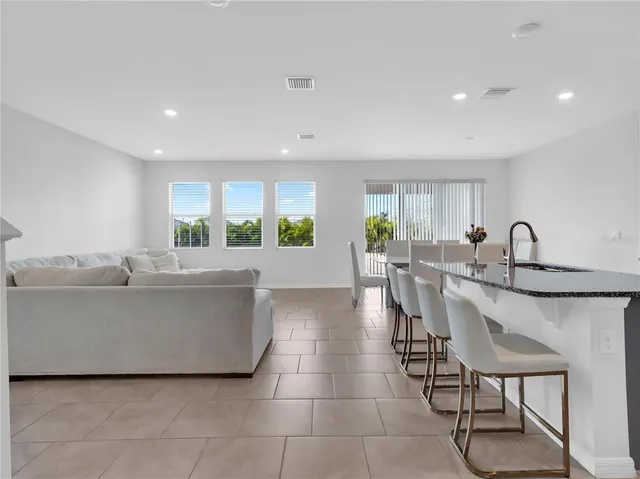 a kitchen with kitchen island granite countertop a sink counter and chairs