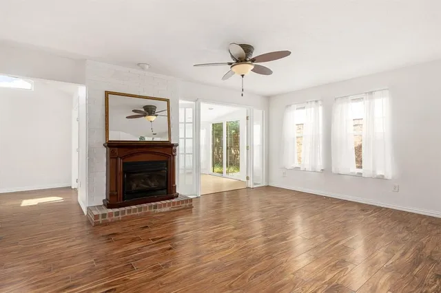 a view of empty room with wooden floor and fireplace