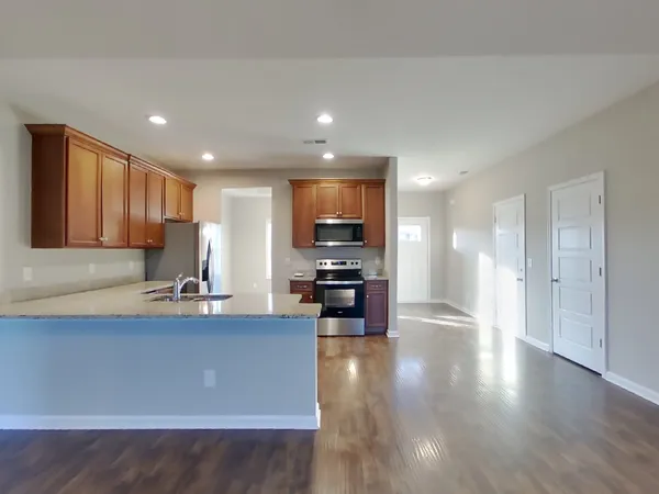 an empty room with a chandelier fan and windows