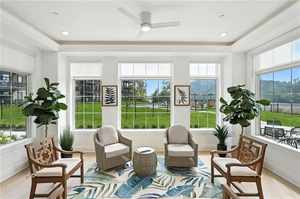 a living room with furniture kitchen and a large window