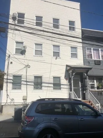 a view of a house with a car parked on road