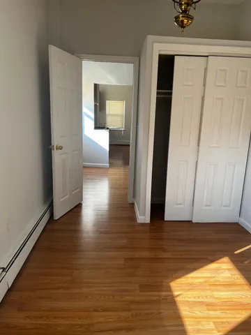 a view of a hallway with wooden floor and closet