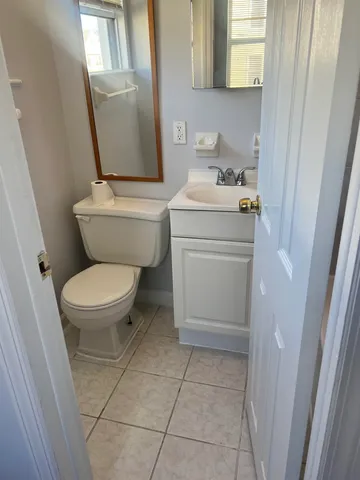 a white toilet sitting next to a bathroom sink and a mirror