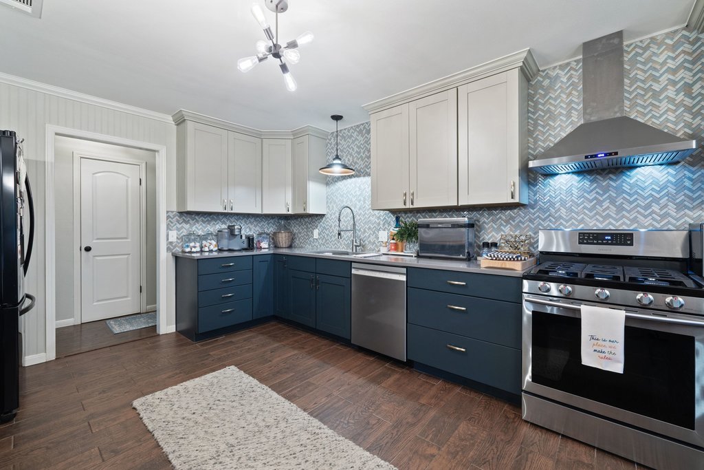 302 South Schramm Road Granger, TX 76530 - Photo 11 of 33 a kitchen with stainless steel appliances granite countertop a stove a sink and a refrigerator