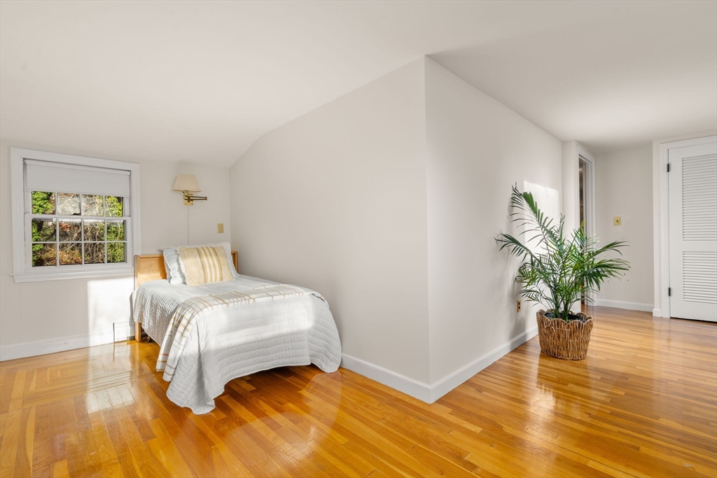 31 White Road Wayland, MA 01778 - Photo 25 of 36 a bedroom with a bed and a potted plant