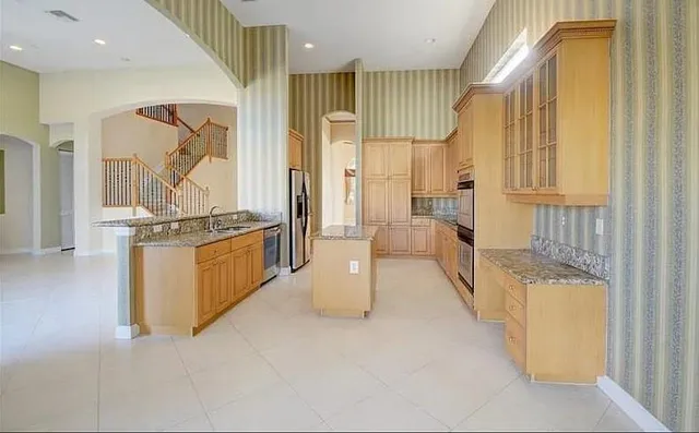 a kitchen with stainless steel appliances granite countertop a refrigerator and a stove
