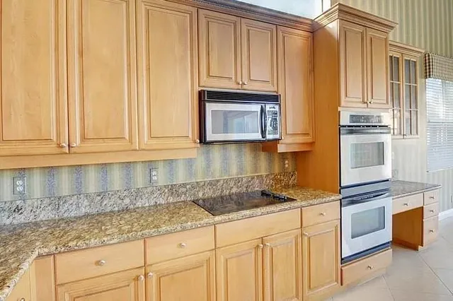 a kitchen with granite countertop white cabinets and stainless steel appliances