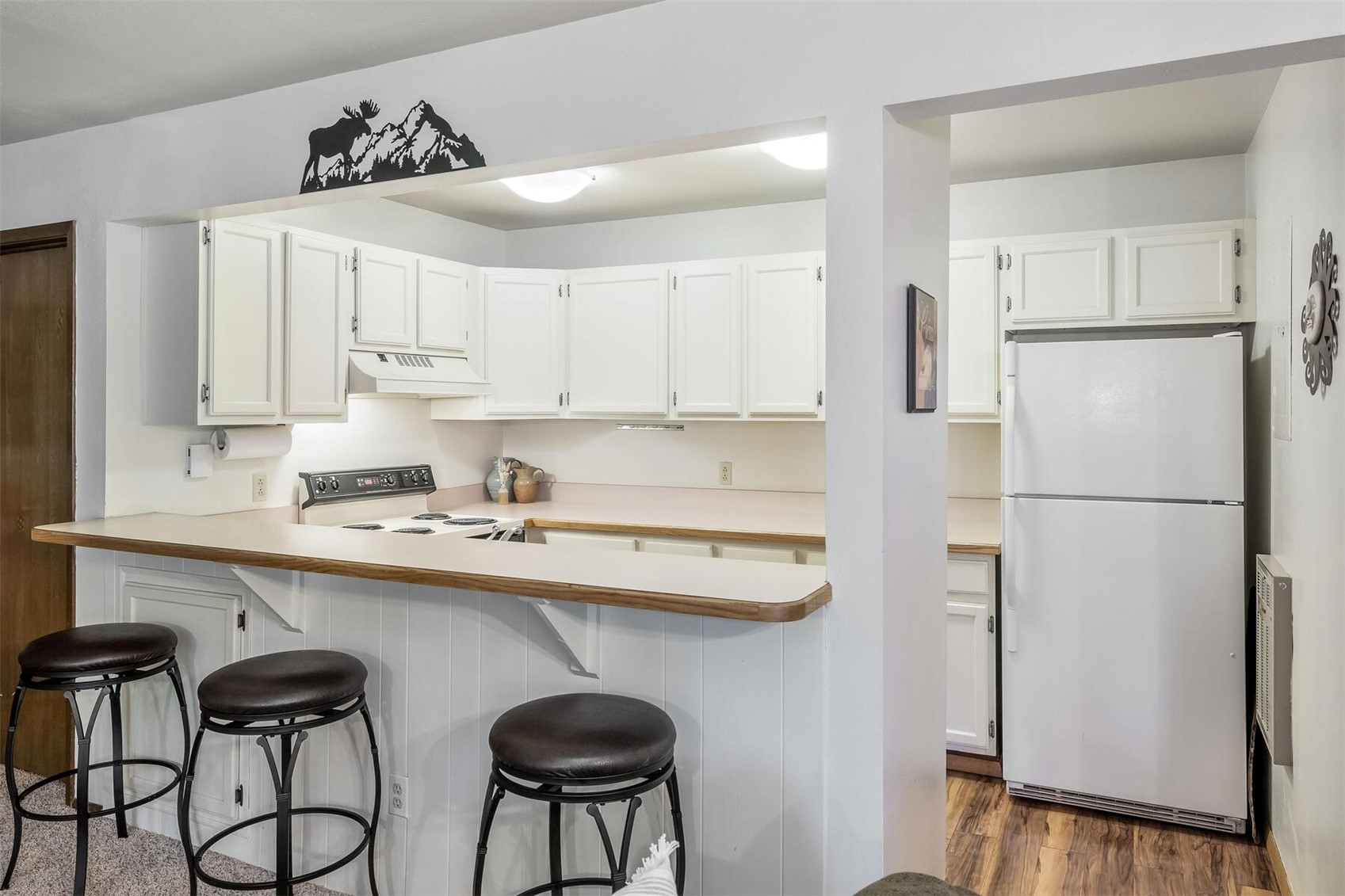 100 Wild Irishman Road, Unit 1103 Keystone, CO 80435 - Photo 8 of 33 Kitchen featuring white appliances, white cabinets, custom range hood, and dark hardwood / wood-style flooring
