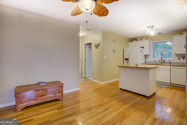 a view of a livingroom with furniture a flat screen tv and a large window with garden view