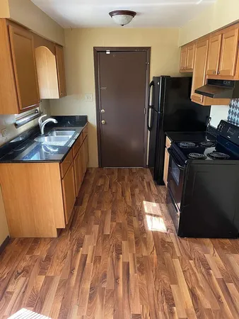 a kitchen with granite countertop a sink stove and refrigerator