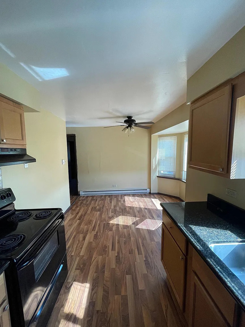 437 Prairie Avenue Calumet City, IL 60409 - Photo 10 of 15 a kitchen with a wooden floor and a stove top oven