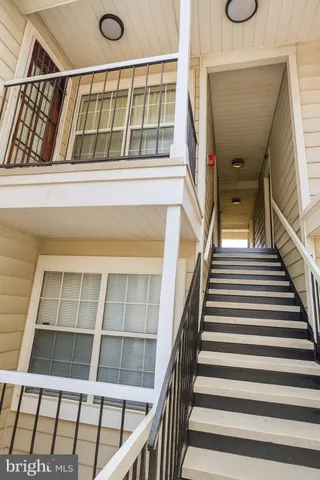 a view of staircase with railing and a window