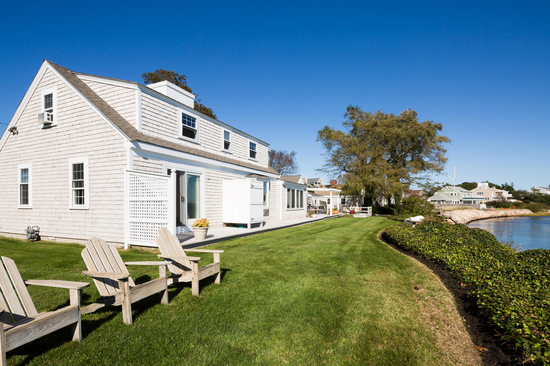 97 Harbor Bluff Road Hyannis, MA 02601 - Photo 7 of 33 a backyard of a house with table and chairs