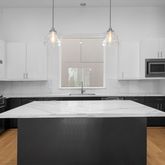 a kitchen with kitchen island a sink stainless steel appliances and cabinets