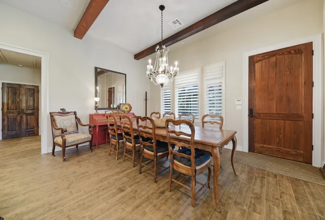 a kitchen with stainless steel appliances a dining table chairs and refrigerator
