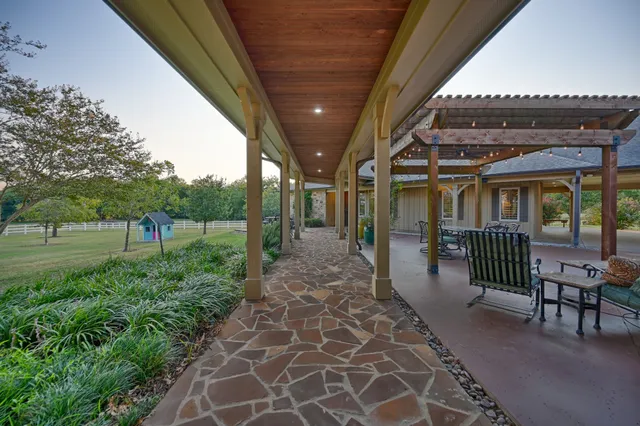 a view of a porch with chairs and floor to ceiling window