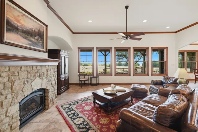 a living room with furniture a fireplace and a floor to ceiling window