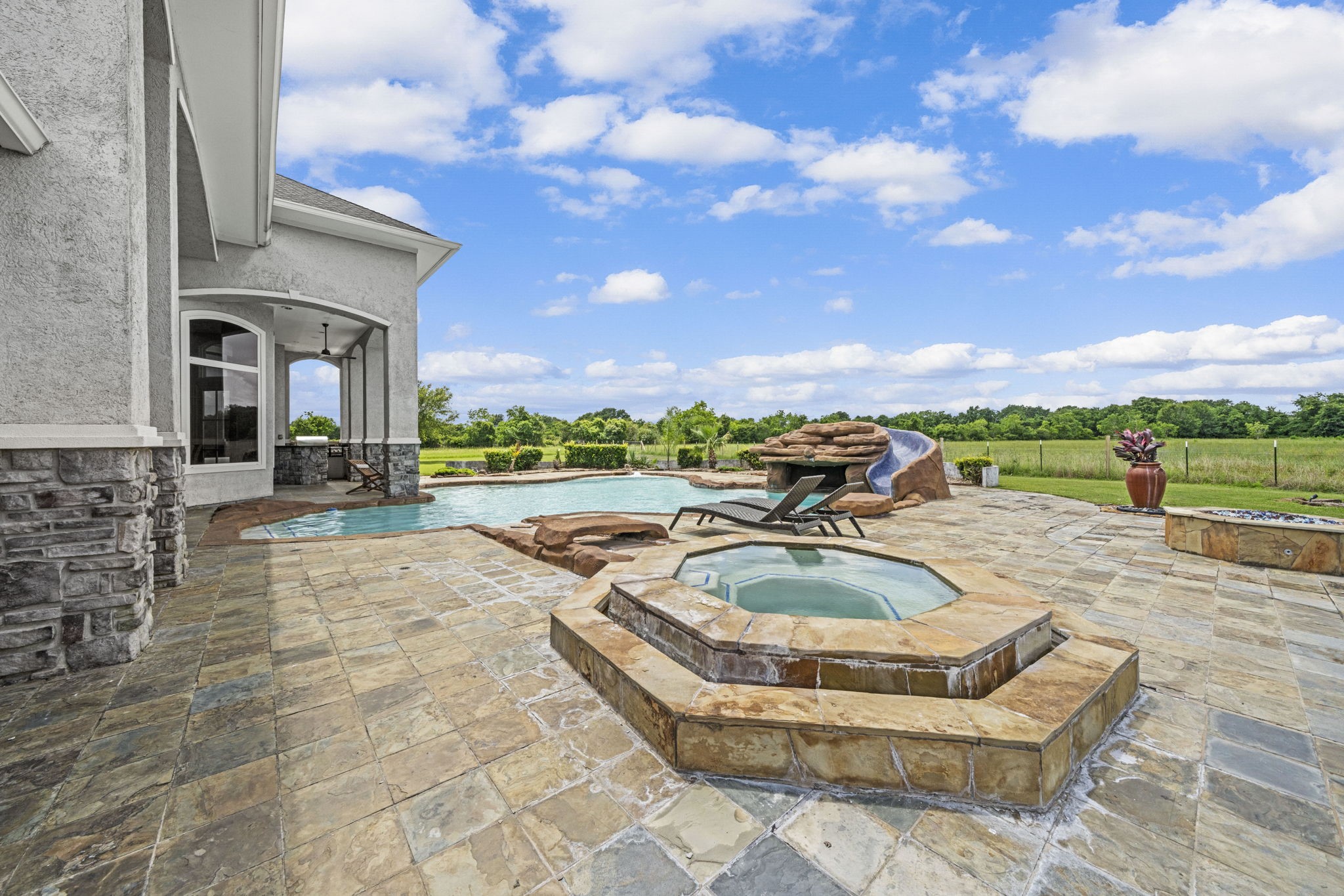 18732 Kz Road Cypress, TX 77433 - Photo 43 of 49 Whether hosting a lively summer pool party or an intimate evening around the firepit, this backyard oasis flows seamlessly from the seating deck to the elevated spa.
