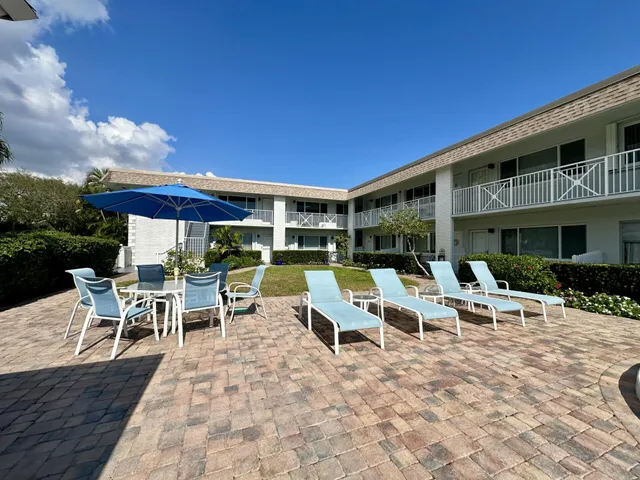 a view of a patio with table and chairs under an umbrella with wooden floor