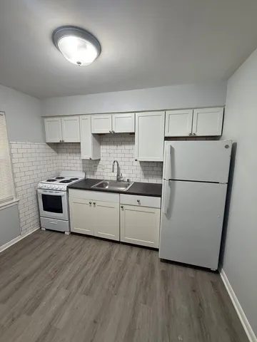 a kitchen with a refrigerator sink and cabinets