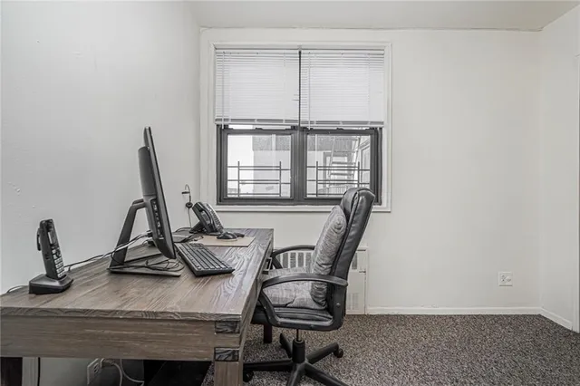 a view of a workspace with furniture and a window