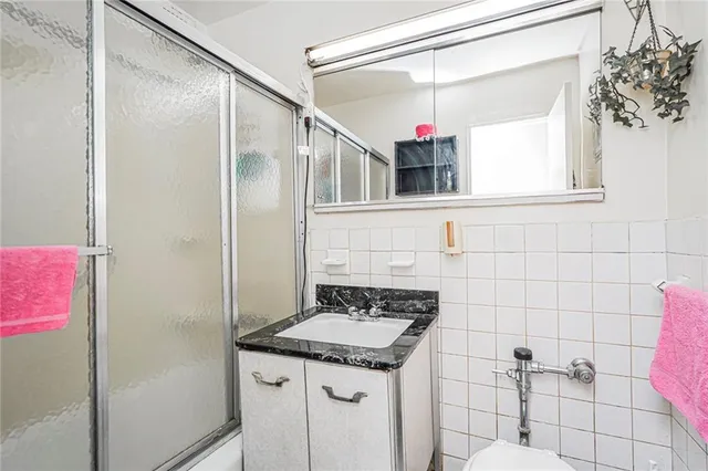 a bathroom with a granite countertop shower sink and mirror