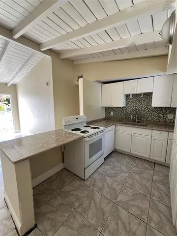 a large white kitchen with a sink and cabinets