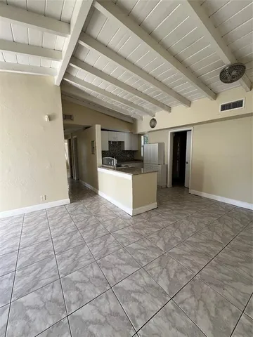 a view of a hallway with wooden floor and kitchen space a sink