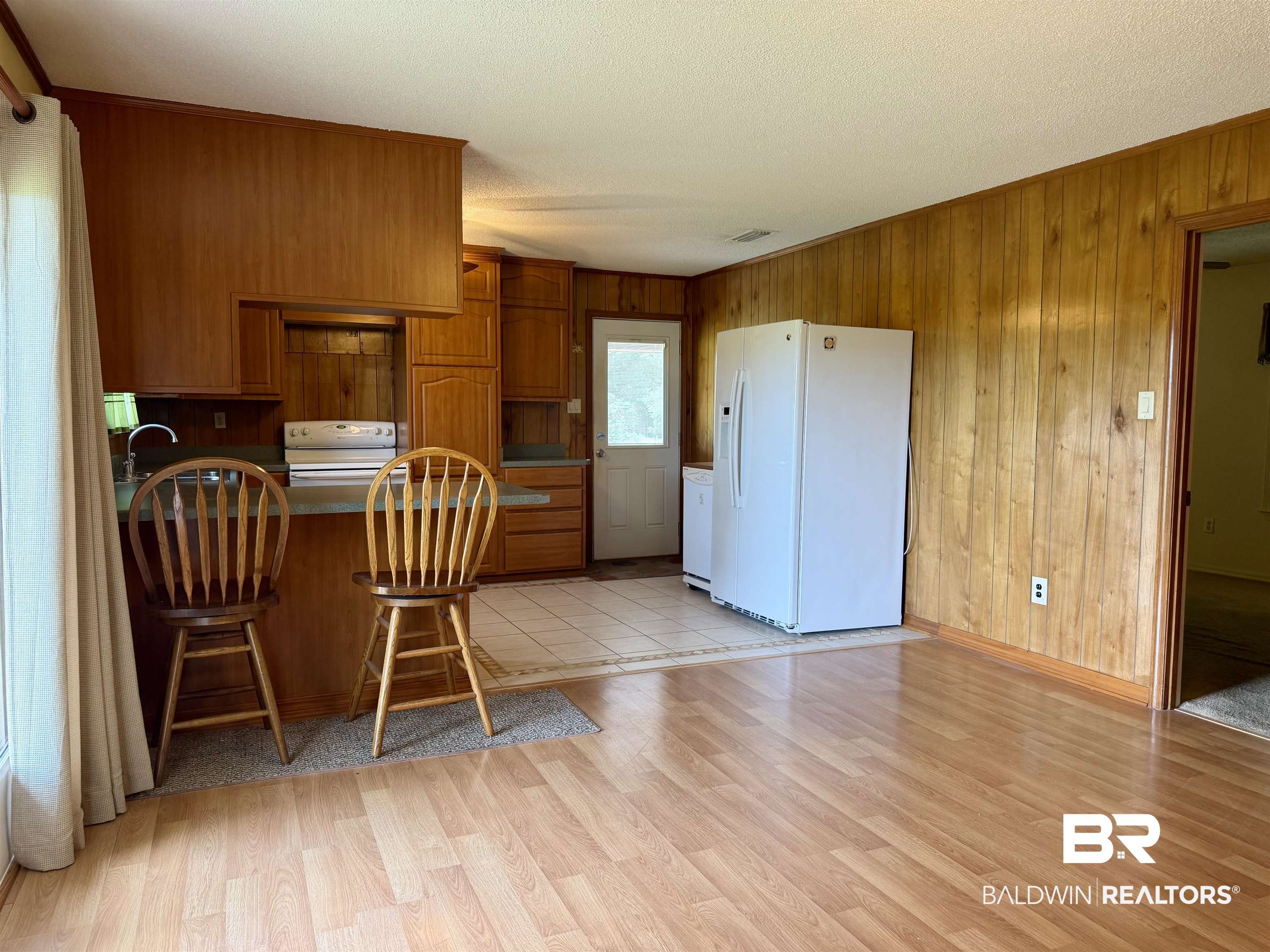 3642 Old Castleberry Road Brewton, AL 36426 - Photo 7 of 14 Kitchen area featuring wood-finish wall paneling and cabinetry