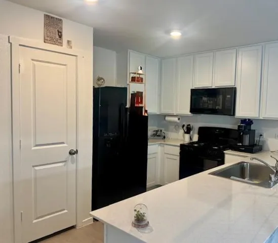 a kitchen with a sink and white cabinets