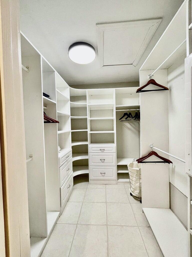 1259 Denlow Lane Royal Palm Beach, FL 33411 - Photo 13 of 40 a view of walk in closet with clothes and shoes