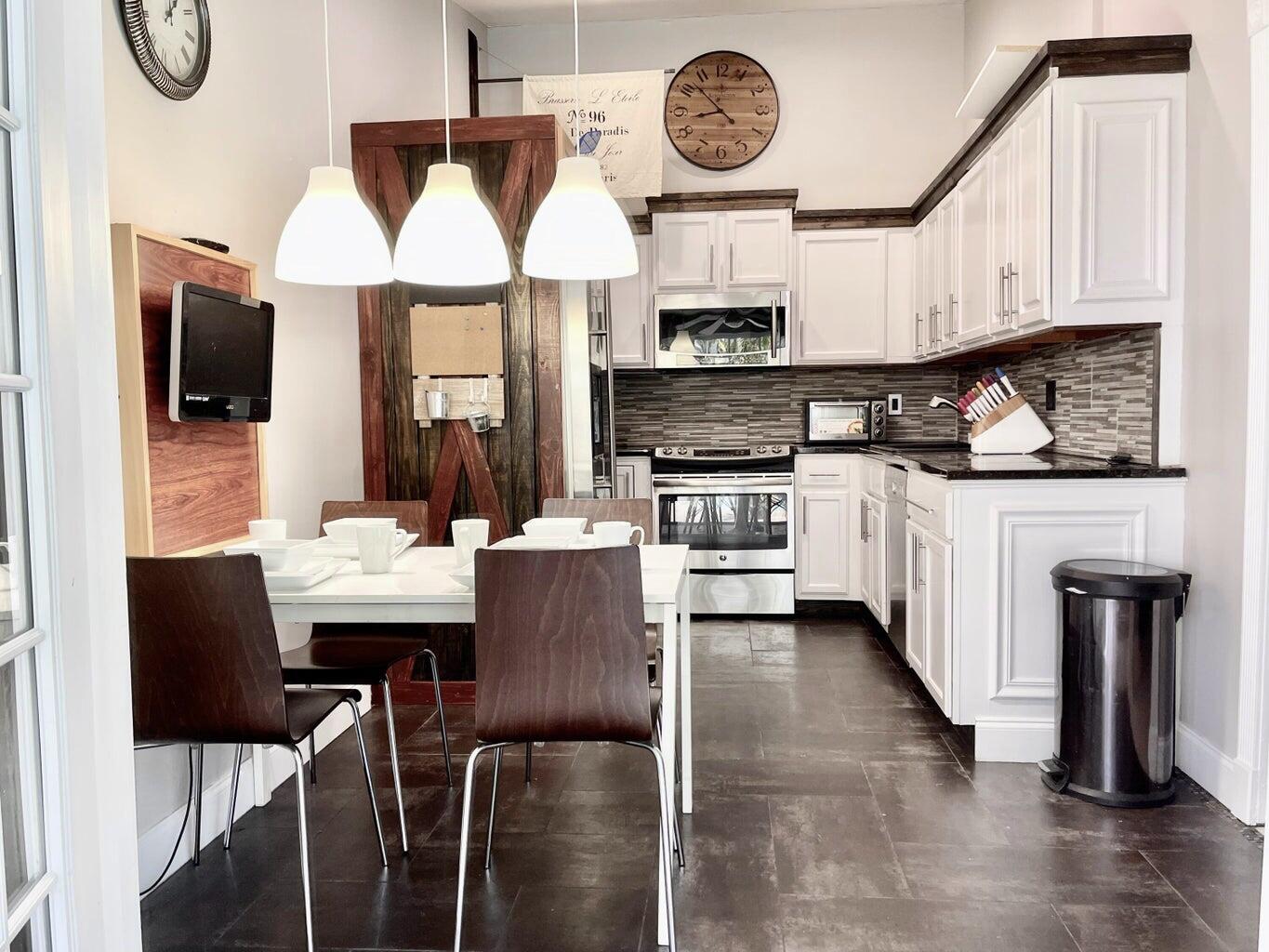 1259 Denlow Lane Royal Palm Beach, FL 33411 - Photo 15 of 40 a kitchen with stainless steel appliances a table chairs and a refrigerator