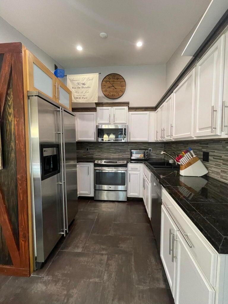 1259 Denlow Lane Royal Palm Beach, FL 33411 - Photo 17 of 40 a kitchen with stainless steel appliances granite countertop a stove a sink and a refrigerator