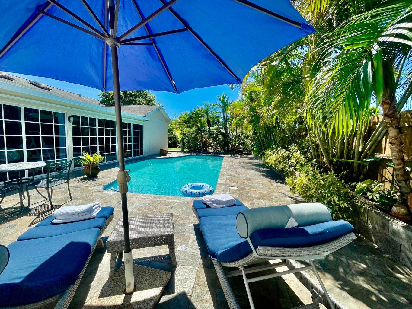 1259 Denlow Lane Royal Palm Beach, FL 33411 - Photo 26 of 40 a view of a backyard with table and chairs under an umbrella