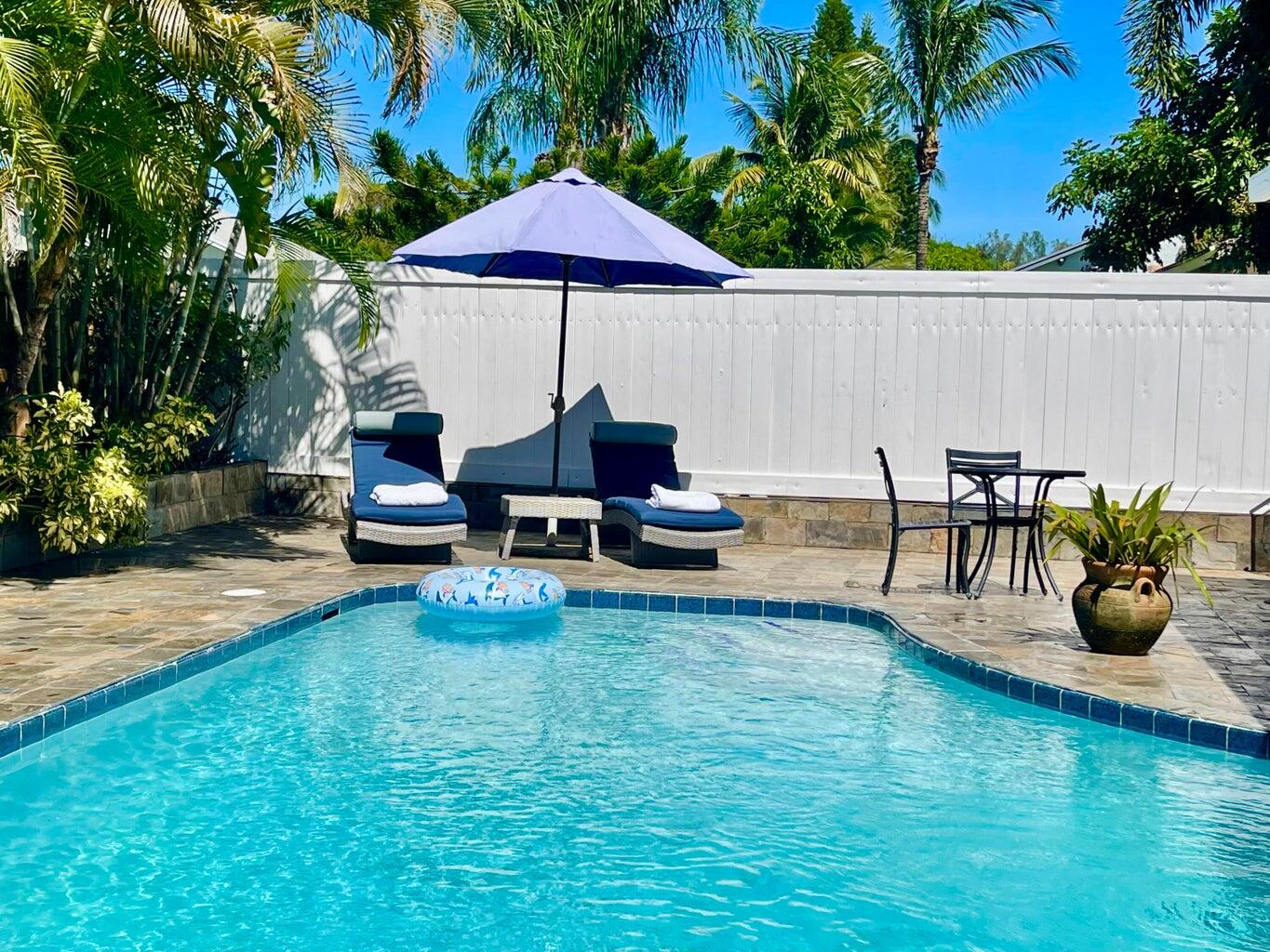 1259 Denlow Lane Royal Palm Beach, FL 33411 - Photo 27 of 40 a view of a backyard with chairs under an umbrella