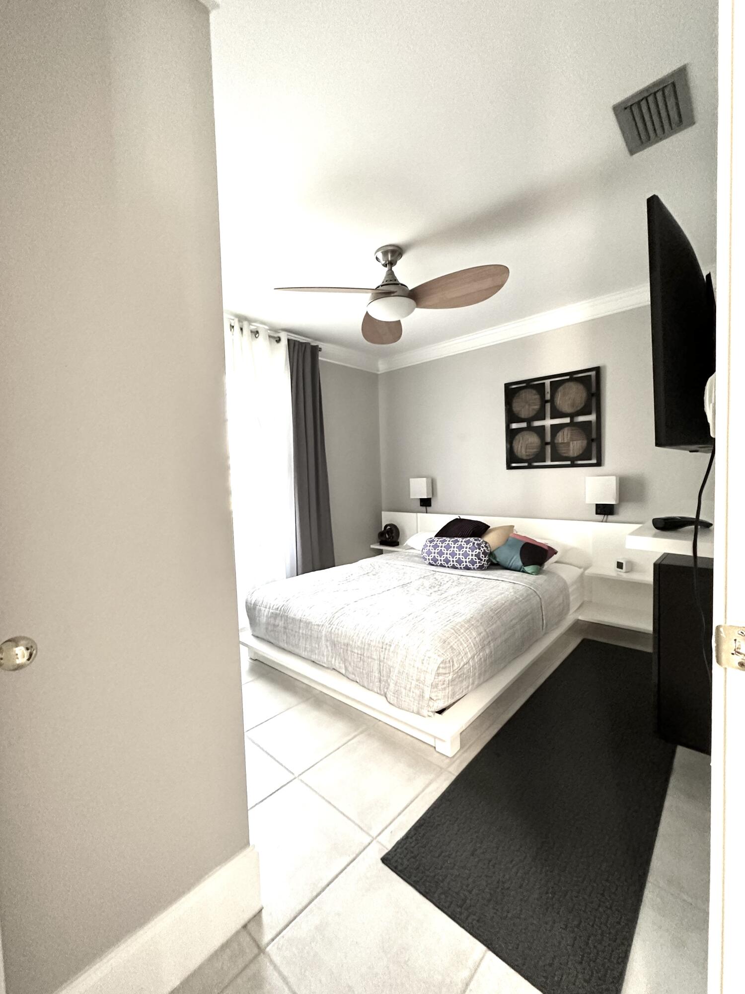 1259 Denlow Lane Royal Palm Beach, FL 33411 - Photo 36 of 40 a bedroom with a bed and a flat screen tv