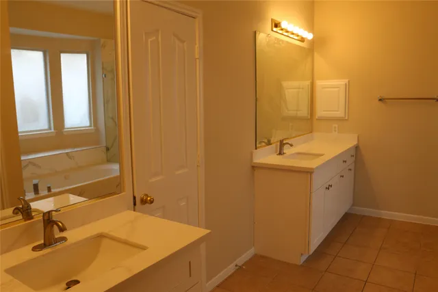 a spacious bathroom with a sink and a mirror