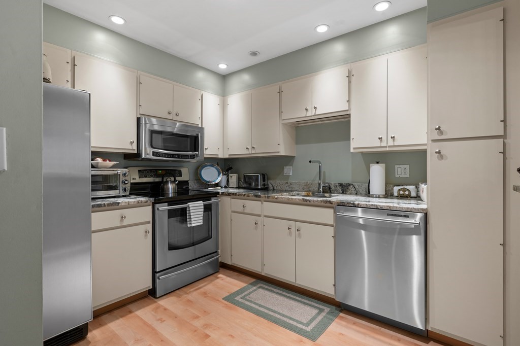 a kitchen with cabinets stainless steel appliances and a sink
