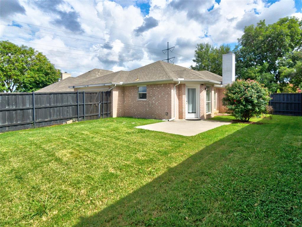 12000 Port Road Frisco, TX 75035 - Photo 37 of 40 Expansive rear yard featuring a brick facade, full privacy fencing, a concrete patio, and a mature flowering shrub