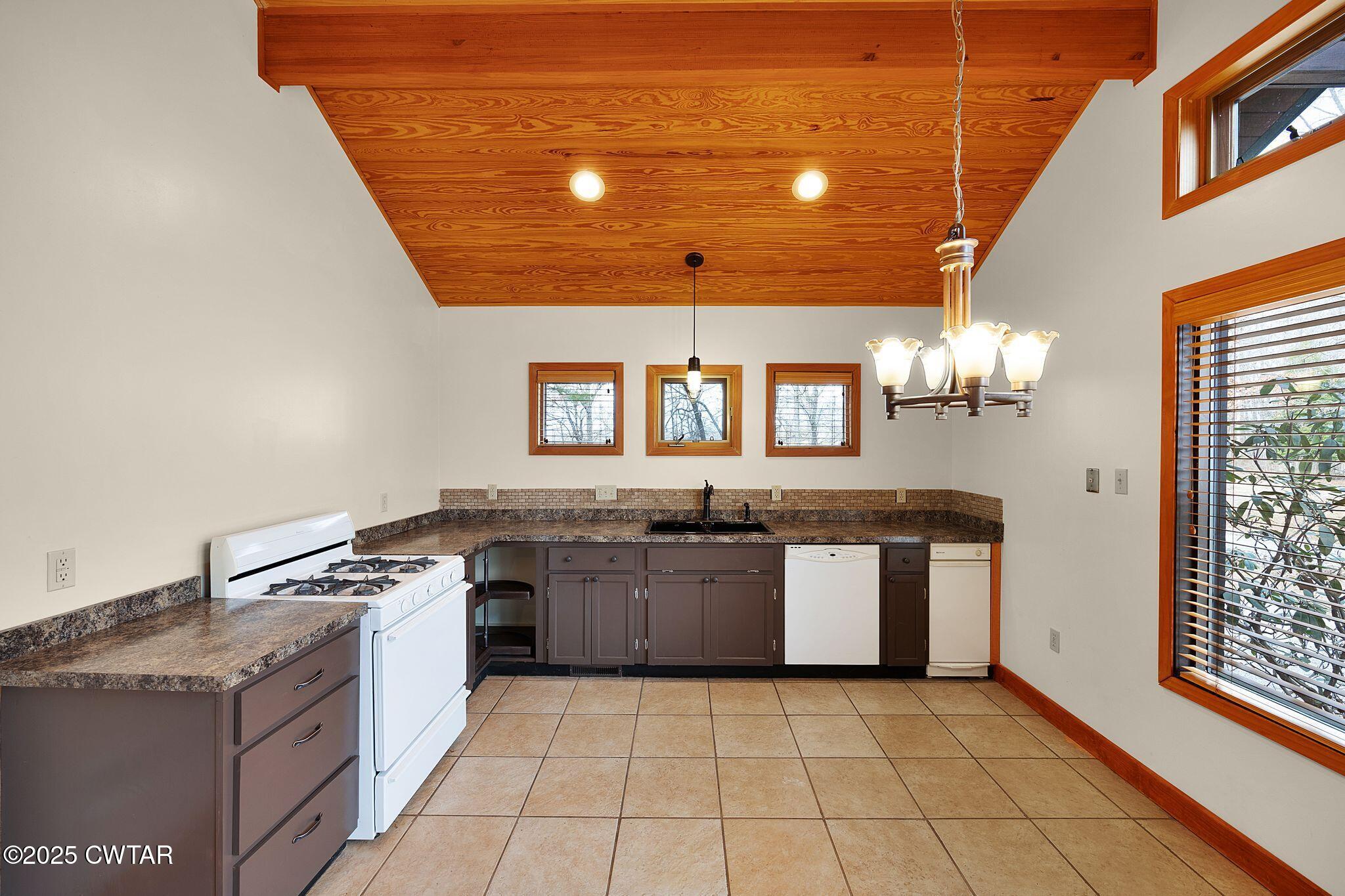 1273 Palmer Road Lexington, TN 38351 - Photo 17 of 62 a large kitchen with granite countertop a stove and cabinets