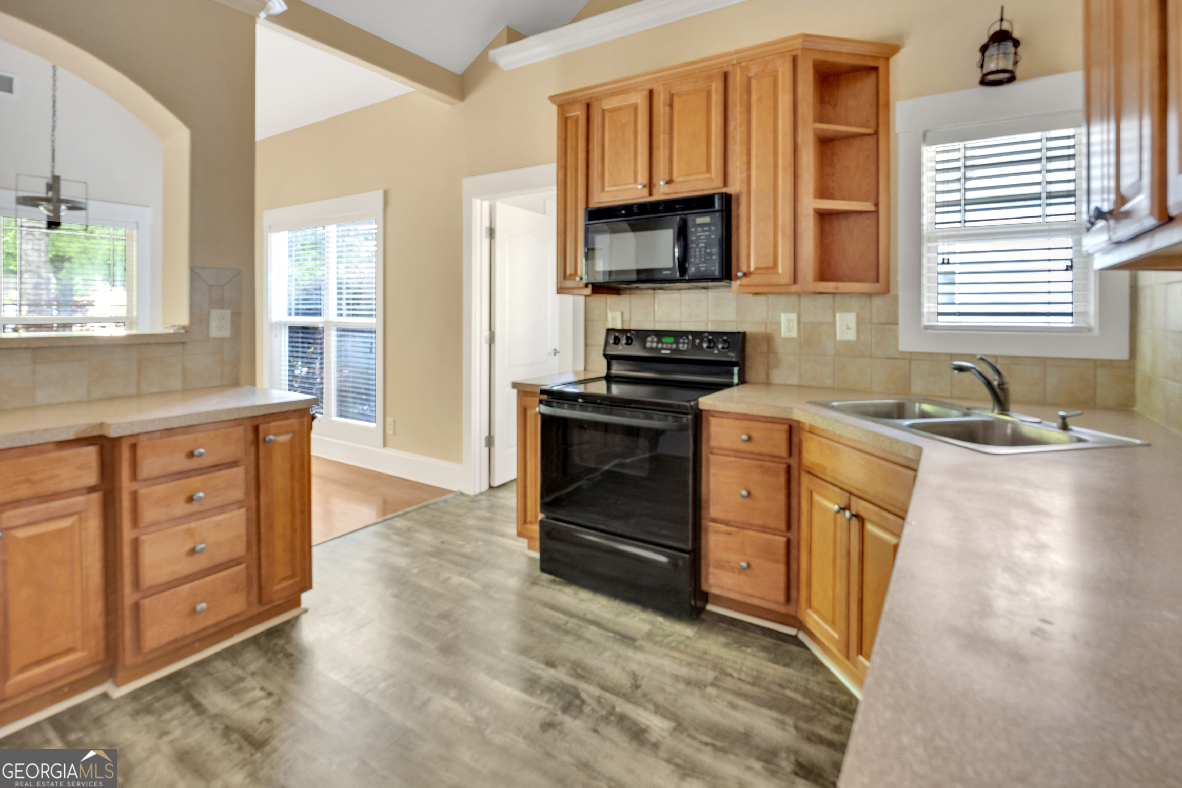 205 Ryan Lane Covington, GA 30014 - Photo 14 of 37 a kitchen with granite countertop a stove a sink and a microwave