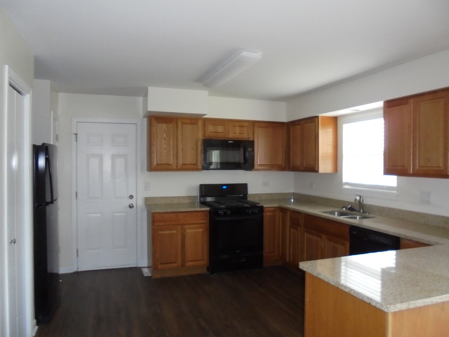 660 West Nippersink Road Round Lake, IL 60073 - Photo 6 of 24 a kitchen with a sink and a stove top oven with wooden floor