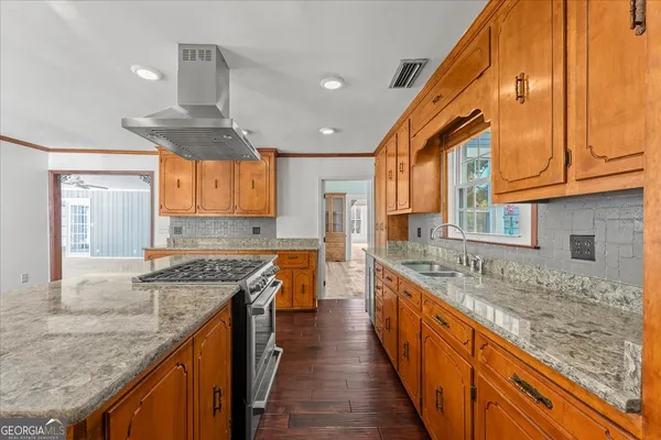 a large kitchen with stainless steel appliances wooden floors and large window