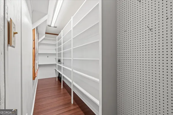 a view of an empty room with cabinet and a bathroom