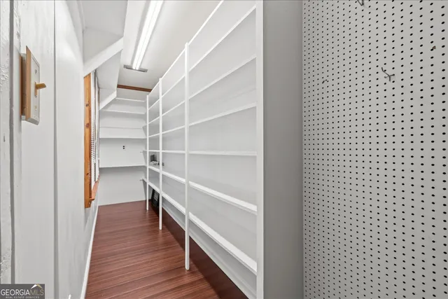 a view of an empty room with cabinet and a bathroom