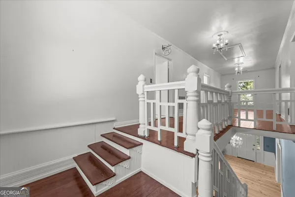 a view of an empty room with wooden floor and closet