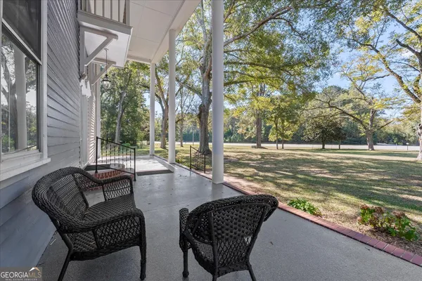 a view of a big room with wooden floor and windows