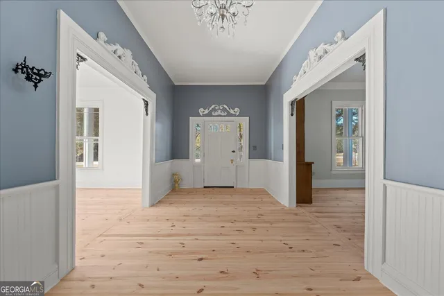 a view of an empty room with wooden floor fireplace and a window