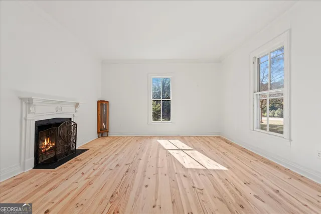 a view of empty room with wooden floor and fireplace