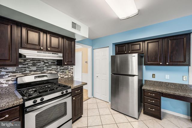 a kitchen with a stove a refrigerator and cabinets